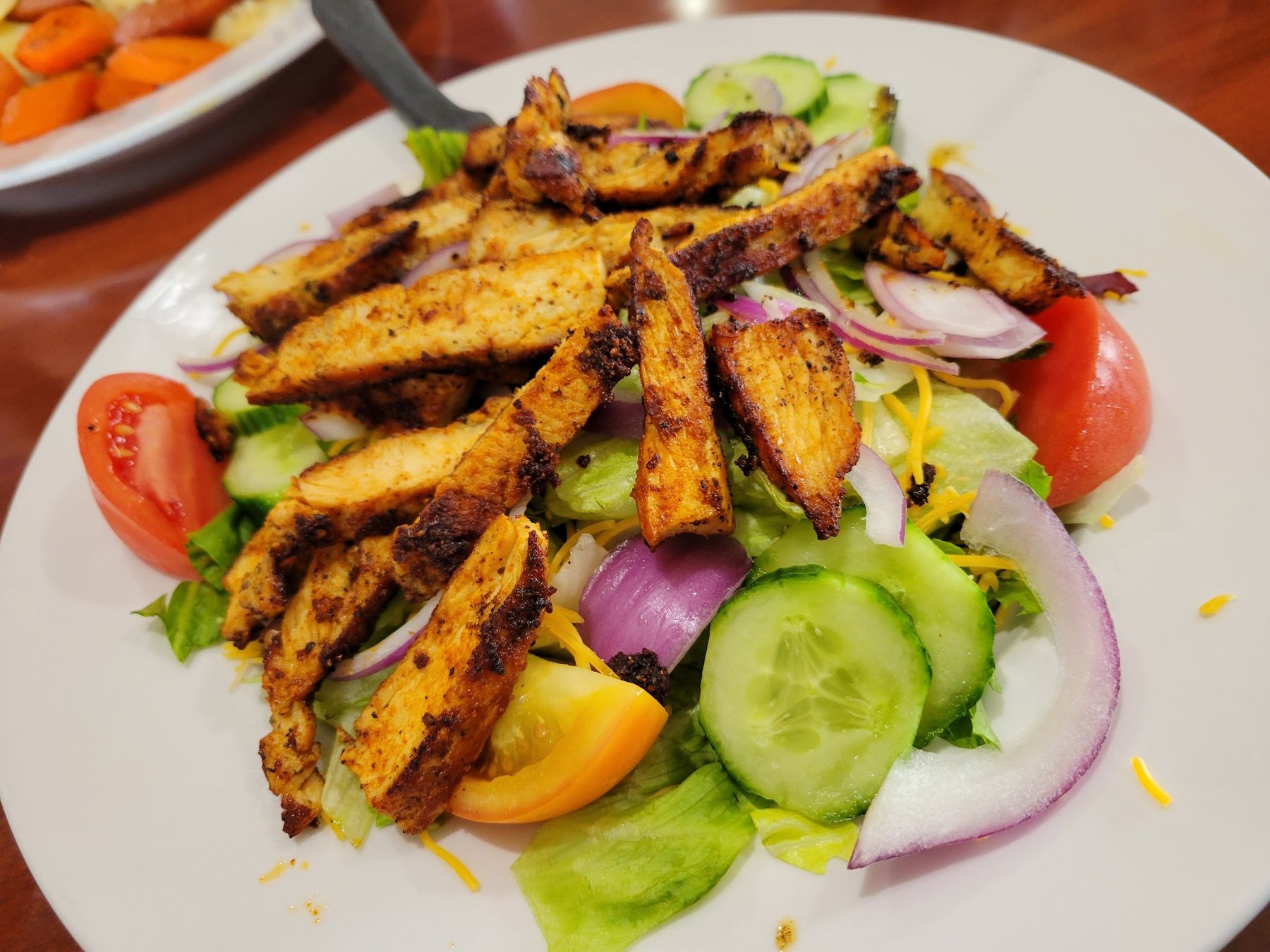 Salad topped with grilled chicken